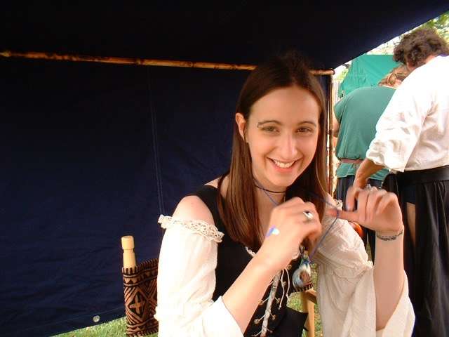 Cris Gale smiling holding a pendant ocarina.